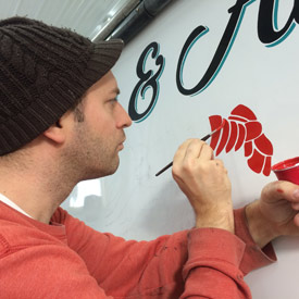 hand painting a boat stern